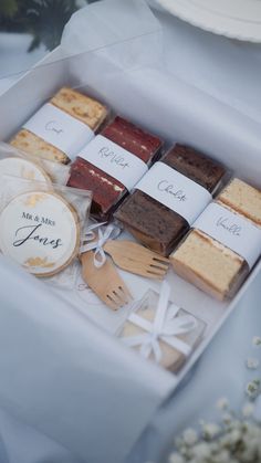 a box filled with lots of different types of cakes and cookies on top of a table