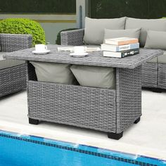 an outdoor lounge set next to a swimming pool with books on the coffee table and two couches