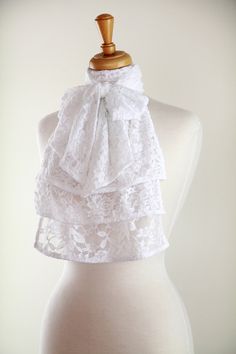 A lovely lace jabot would be a delightfully unique edition to any vintage fashion lover's wardrobe!! Pair this ruffled fashion collar with a little black dress for a simply elegant evening look, or wear it under a tuxedo jacket with jeans and it has rock star appeal!! This handmade neckwear frill features a cascade of gorgeous floral lace and a wrap around style neckband that ties in a bow in the front to complete the vintage-inspired look!!  Stretch lace fabric gives it an unusually comfortable Elegant Lace Patchwork For Ceremony, Elegant Lace With Patchwork For Ceremony, White Lace Patchwork For Formal Occasions, White Lace With Patchwork For Formal Occasions, Formal White Lace With Patchwork, Chic Wedding Lace With Lace Trim, Elegant Formal Lace With Lace Patchwork, Elegant Lace With Lace Trim For Ceremony, White Ruffled Lace For Wedding