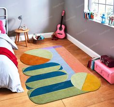 a child's bedroom with a guitar on the floor and rug in the middle