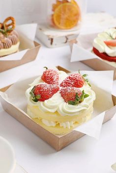 there are many different desserts in the box on the table, including strawberries and oranges