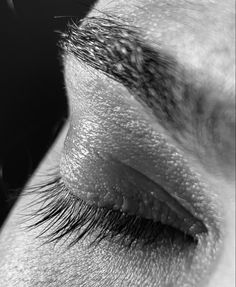 the eye of a woman with long lashes and eyelashes are shown in black and white