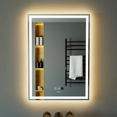 a bathroom with a sink, mirror and towel rack in the reflection on the wall