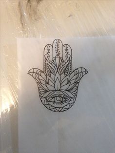 a piece of paper with a drawing of a hamsa hand on it's side