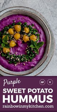 purple sweet potato hummus in a bowl with green leaves and sprinkles