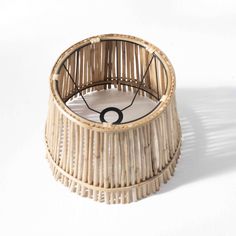 a bamboo basket with a black ring on the top and white flooring around it