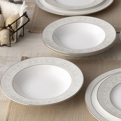 four white plates sitting on top of a table