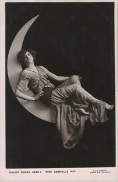 an old photo of a woman laying on the moon with her eyes closed and hands behind her back