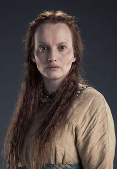 a woman with long hair wearing a brown dress