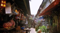 an alley way with lots of shops and plants