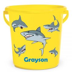 a yellow bucket with sharks on it and the words grayson written in blue ink