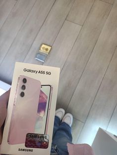 someone holding up a pink samsung case in front of a box with the phone inside