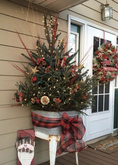 a potted christmas tree sitting on top of a porch