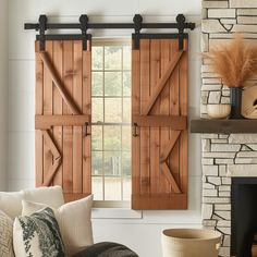 a living room with a fireplace and two wooden shutters on the doors that are open