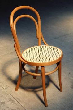 a wooden chair sitting on top of a cement floor