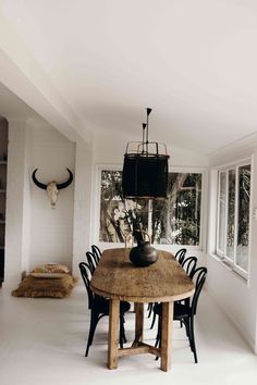 a dining room table with chairs and an animal head on the wall