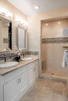 a large bathroom with two sinks and a shower stall in the corner, along with a walk - in shower