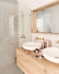 two white sinks sitting under a mirror in a bathroom next to a walk in shower