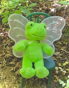 a green teddy bear sitting in the grass