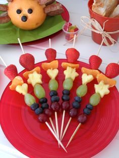 fruit skewers are arranged on a red plate