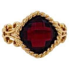 Adorn a magnificent finger with this gorgeous 3.50 carat garnet ring! Garnet is January's birthstone and this gorgeous ring will be a fabulous way to celebrate your January loved one. The rich color of the garnet is accented by the checkerboard facets and warm gold setting. Stylized fleur-de-lis designs accent the band of the ring below the bold twisted cable bezel around the delightful cushion garnet. This ring is marked down from the original price of $1,350. Wear a piece that speaks to your style! Classy and bold, but graceful. This ring is a size 7 and it can be sized upon request. Please note that if the ring is resized for you, the item becomes a custom final sale and cannot be returned. Thank you for understanding. The details for this beautiful ring are listed below: Metal Quality: