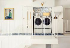 a washer and dryer in a room with stairs leading up to the second floor