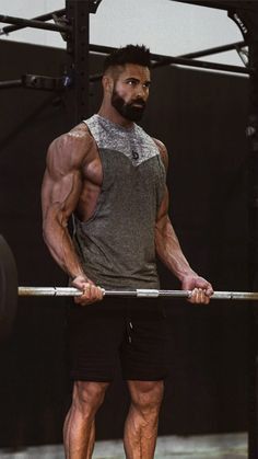 a man with a beard and no shirt is holding a barbell