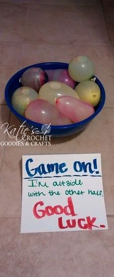 a bowl full of balloons sitting on the floor next to a sign that says come out