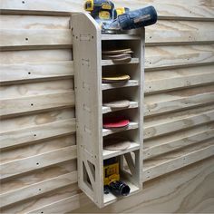 a wooden shelf with several pairs of shoes on it and a drill holder next to it