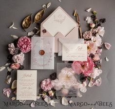 the wedding stationery is surrounded by pink flowers