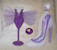 a purple shoe next to a wine glass and candle holder