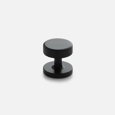 a black knob on a white background with no one around it or someone else to the right