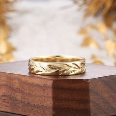 a gold wedding ring sitting on top of a wooden box