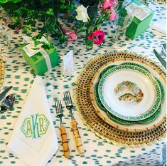 the table is set with plates, silverware and green napkins for an elegant dinner