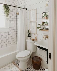 a white bathroom with black and white tile flooring, shower curtain, toilet and sink