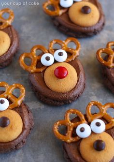 chocolate cookies decorated with pretzels and googly eyes are arranged in the shape of reindeer heads