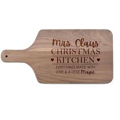 a wooden cutting board with the words mum claus's christmas kitchen on it