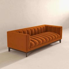 an orange couch sitting on top of a white floor