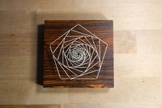 a wooden box with string art on it