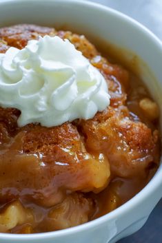 a close up of a bowl of food with whipped cream on top