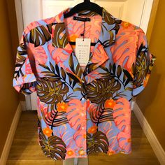 Hawaiian Blouse Size Large Salmon Color Leaves, Blue And Brown, Orange Flowers. Some Black Button Down, Cuff Sleeves 100% Polyester, Has Some Stretch Armpit To Armpit Is About 23 Inches Pink Buttoned Shirt For Vacation, Pink Tropical Print Short Sleeve Blouse, Trendy Short Sleeve Blouse With Tropical Print, Pink Buttoned Beach Blouse, Pink Button-up Blouse For Vacation, Pink Blouse With Buttons For The Beach, Pink Blouse With Button Closure For Vacation, Vacation Button-up Blouse With Tropical Print, Vacation Tropical Print Button-up Blouse