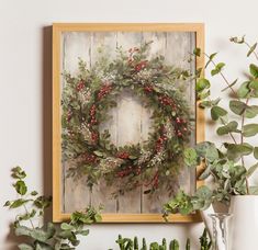 a painting of a wreath on a wall next to potted plants and vases