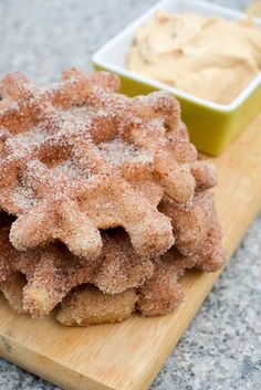 a wooden cutting board topped with sugar covered cookies