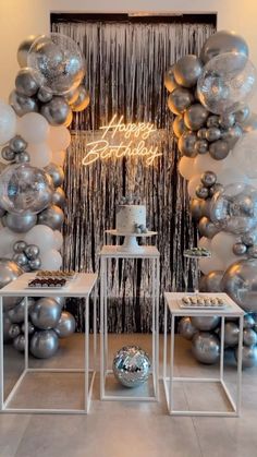 a room filled with balloons and silver decorations