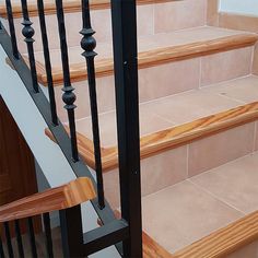 the stairs are made of wood and have black handrails