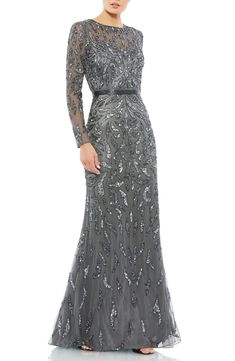 Beads and sequins placed in an abstract leaf pattern create an elegantly windswept landscape on this flowing gown with a twinkling beaded neckline and waist. Jewel neck Long sleeves Lined 100% polyester Spot clean Imported Asian Owned/Founded Mocha Dress, Designer Formal Dresses, Long Sleeve Evening Gowns, Sheath Gown, Long Sleeve Gown, Evening Dresses Cocktail, Column Gown, Party Dress Long Sleeve, Long Sleeve Sequin