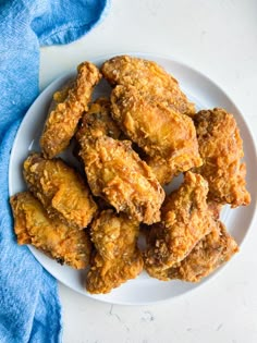 fried chicken on a white plate with a blue towel