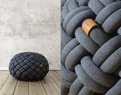 a large gray pillow sitting next to a small black ball on top of a wooden floor