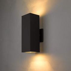 a wall mounted light that is on the side of a wall in an empty room