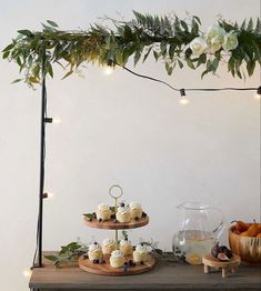 a table topped with cakes and cupcakes next to a potted plant